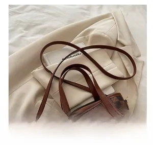 Close-up of vintage brown checkered bucket bag with golden hardware and leather strap