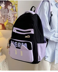 Detail of laptop backpack with cat ear design, purple straps, and plush pendant accessory