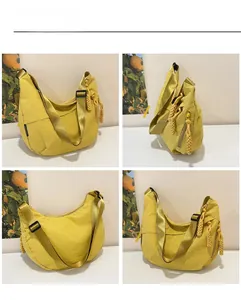 Dettaglio borsa a mezzaluna in nylon giallo con zip in corda e tracolla larga