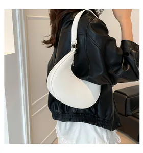 Side view of woman wearing a white crescent hobo bag with lychee pattern leather