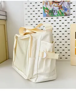 Detailed view of cream ita bag with a large transparent PVC window and side buckle