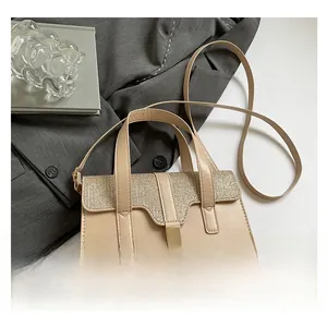 Détail du rabat pailleté doré champagne et du fermoir rotatif en métal du sac beige