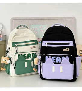 Detail of cute cat-ear backpacks with plush charms in beige-green and black-purple styles