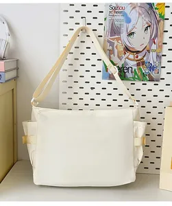 Detail of adjustable wide shoulder strap and side storage pocket on the cream student bag