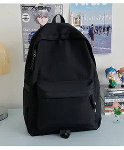 Detail view of a large black nylon student backpack in a cozy study desk scene