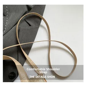 Détail de la bandoulière confortable en cuir PU beige avec des coutures soignées sur le sac