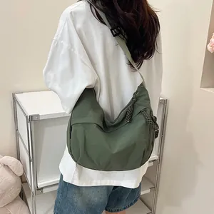 Dettaglio della borsa hobo verde scuro capiente con tracolla regolabile e tessuto in nylon