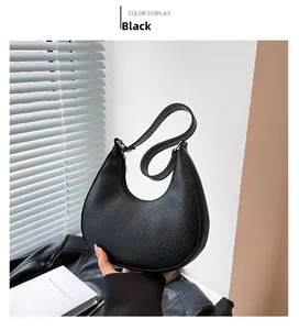 Detail of black pebbled leather hobo shoulder bag with a sleek minimalist strap
