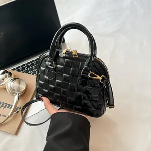 Glossy black embossed checkered shell bag with golden hardware and luxury texture