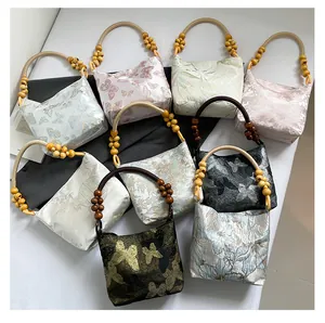 Détails des motifs brodés et des poignées en perles de bois sur des sacs de style ethnique