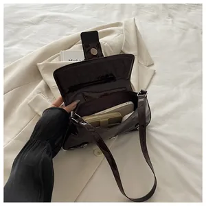 Detail view of the deep wine red patent leather shoulder bag showing interior capacity