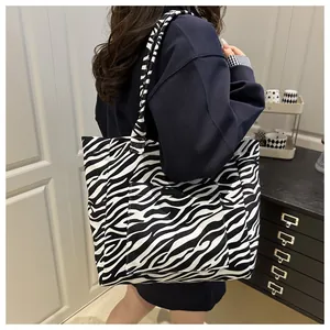 Detail of zebra print canvas tote bag with functional exterior pocket and dual straps