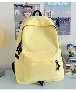 Detail of a minimalist light yellow nylon backpack showing large front zipper pocket