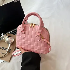 Pink shell bag featuring textured lattice pattern and elegant gold dual zippers