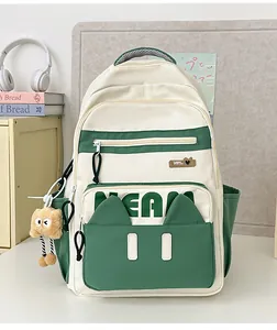 Detail of cute cat-ear pocket and plush charm on cream and green student backpack