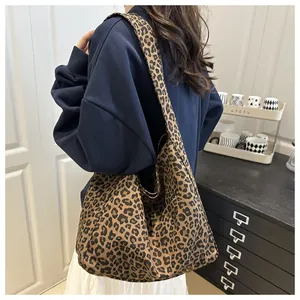 Detail of leopard print canvas tote bag showing wide strap and large capacity texture