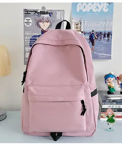 Pale pink nylon backpack displayed on a desk with magazines and anime figures