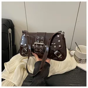 Detail of dark brown punk shoulder bag with glossy patent finish and silver studs