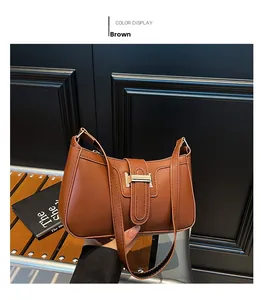 Detailed view of the brown crescent bag with smooth leather texture and gold hardware