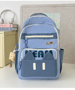 Detail of blue two-tone school backpack with cute cat ear pocket and meow lettering