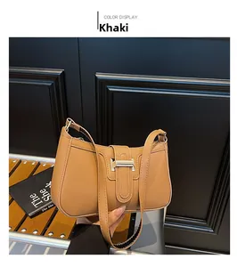 Detail of khaki crescent underarm bag showing smooth texture and metal snap closure
