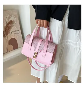 Détail du sac à main rose façon croco avec rabat à paillettes et ferrures dorées