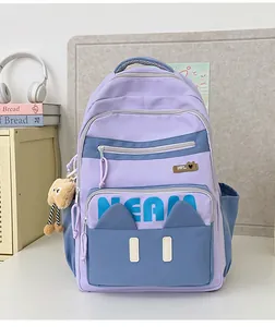 Detail of purple laptop backpack with cute cat-ear pockets and plush toy charm