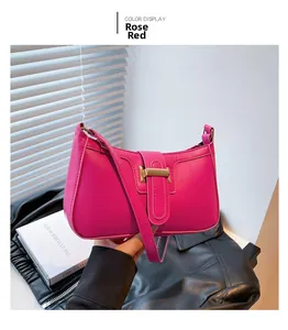 Detail view of the rose red crescent bag with elegant gold metal buckle and smooth leather
