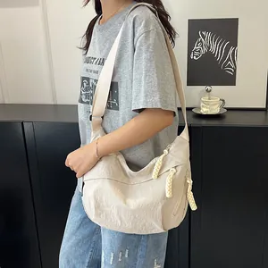 Dettaglio della borsa hobo in nylon bianco crema con cerniera in corda intrecciata