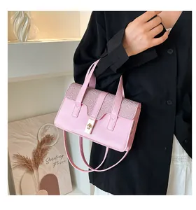 Détail du sac à main rose en simili cuir avec rabat pailleté et fermoir rotatif doré