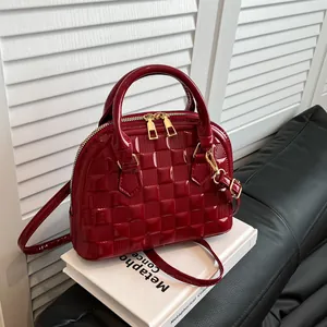 Detailed macro view of ruby red shell bag with glossy woven texture and gold hardware