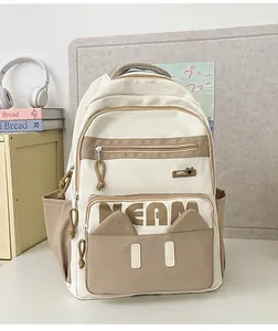 Detail of minimalist beige and khaki school backpack with MEAM logo in a study setting
