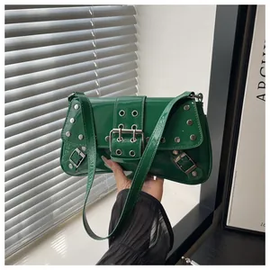 Close-up of green patent leather shoulder bag with silver studs and metal buckle