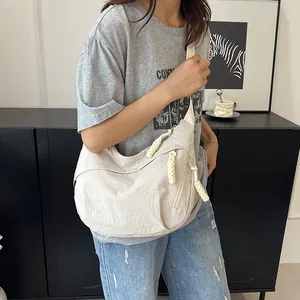 Dettaglio della borsa a mezzaluna bianco sporco in nylon con tirante della zip in corda di cotone