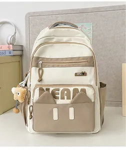 Detail of laptop backpack with cute cat ears and bear keychain in school setting