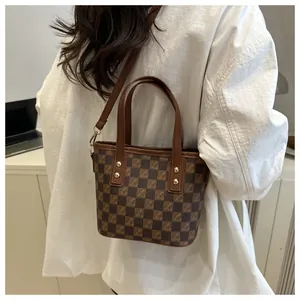 Detail view of retro checkered tote bag featuring gold hardware and detachable strap