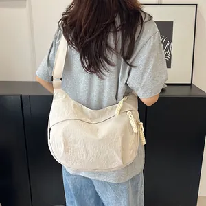 Dettaglio borsa a tracolla in nylon bianco panna con zip in corda intrecciata e cinturino