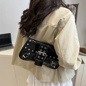 Punk style black patent leather shoulder bag with silver studs and Y2K metal eyelets