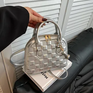 Silver quilted shell-shaped handbag with golden hardware and detachable shoulder strap