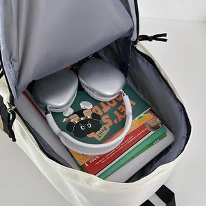 Large capacity ivory nylon backpack for students showing spacious interior with lining