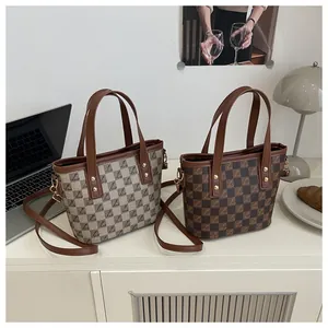 Detail of vintage tote bags with checkered pattern, metallic rivets and brown leather trim