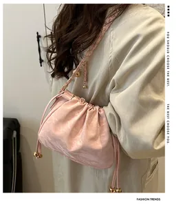Detailed view of the pale pink cloud bag with chain strap and drawstring gold beads