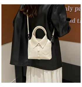 Detail of shirt-style white crossbody bag featuring collar design and embossed leather logo