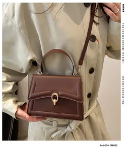 Schicke dunkelbraune Vintage-Handtasche mit goldenem Ringverschluss und eleganten Ziernähten