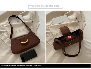 Dettaglio borsa a spalla in pelle scamosciata marrone scuro con fibbia d'oro e interno