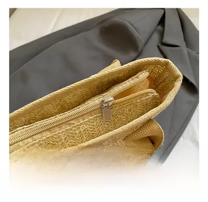 Detail showing the durable metal zipper closure on the straw woven bucket handbag
