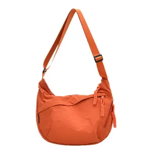 Grande borsa a mezzaluna arancione in nylon con tracolla regolabile e zip intrecciate