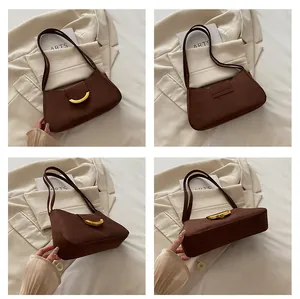 Dettaglio della borsa baguette in pelle scamosciata marrone scuro con fibbie dorate e varie viste