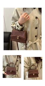 Detail der braunen Handtasche mit goldener Ringschnalle und verstellbarem Trageriemen