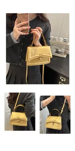 Detail der champagner-goldenen Handtasche mit Metallic-Finish, festem Griff und Metallschloss